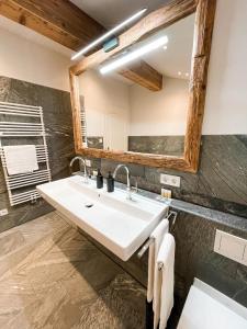 ein Bad mit einem Waschbecken und einem Spiegel in der Unterkunft Natur pur - Doppelhaushälfte im idyllischen Kreuth in Kreuth