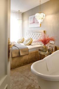 sypialnia z łóżkiem z żyrandolem w obiekcie La Rose Residence w mieście Mikołajki