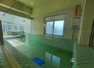 a room with a swimming pool in a building at SongJeong Lesign Hotel in Busan