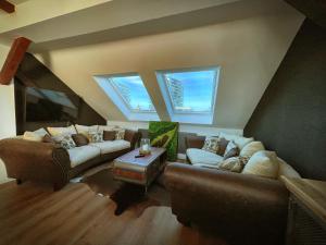 een woonkamer met 2 banken en 2 ramen bij Studio Hundertwasser in Erfurt