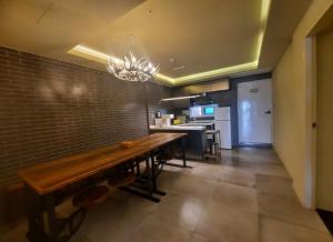 a dining room with a wooden table and a kitchen at SongJeong Lesign Hotel in Busan