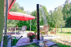 a patio with an umbrella and a table and chairs at Ferienhaus Crosta Brava in Großdubrau