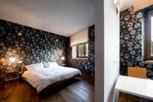 莫羅達爾巴的住宿－Le Civette，一间卧室配有床和壁纸覆盖的墙壁