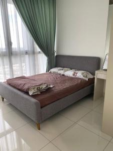 uma cama num quarto com uma janela em Eco Nest 3 Bedroom Duplex Apartment em Nusajaya