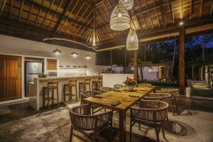a kitchen and dining room with a wooden table and chairs at Umah Shama in Ubud