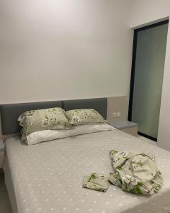 uma cama com alguns lençóis e almofadas em Eco Nest 3 Bedroom Duplex Apartment em Nusajaya
