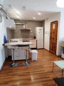 Apartamento con encanto Mila VALENCIAYOLE في فالنسيا: مطبخ مع أرضية خشبية وأجهزة بيضاء