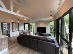 a living room with a couch and a television at Tinswari Self-catering Chalet in Hluhluwe