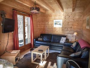 a living room with a leather couch and a table at Chalet La Rose in Montriond