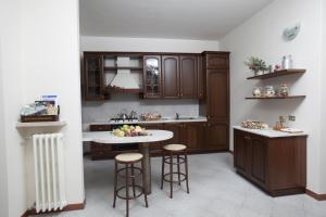 a kitchen with wooden cabinets and a island with bar stools at Bed & Breakfast Conca Verde in Cavriana