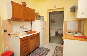 La cuisine est équipée d'un évier et d'un réfrigérateur blanc. dans l'établissement Apartments with a parking space Novi Vinodolski - 5582, à Novi Vinodolski