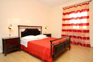 a bedroom with a bed with a red blanket at Secluded family friendly house Kapelica, Labin - 5536 in Raša