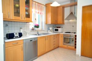 a kitchen with wooden cabinets and a sink and a microwave at Secluded family friendly house Kapelica, Labin - 5536 in Raša