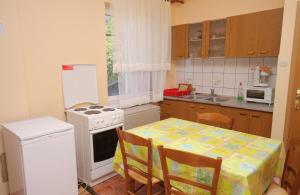 una cucina con tavolo e piano cottura bianco con forno di Studio Senj 5560a a Senj