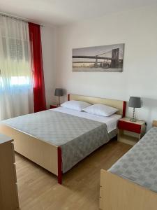 a bedroom with two beds and two tables with lamps at Apartments with WiFi Crikvenica - 5555 in Crikvenica