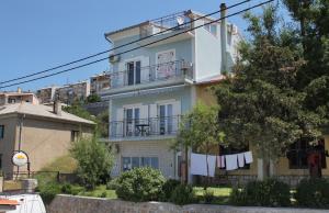 a white house with a clothes line in front of it at Apartments and rooms with WiFi Senj - 5560 in Senj