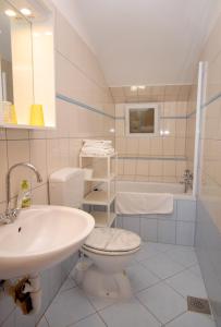 łazienka z umywalką, toaletą i wanną w obiekcie Apartments and rooms with WiFi Senj - 5560 w mieście Senj