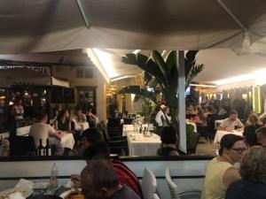 un grupo de personas sentadas en mesas en un restaurante en Calle Goya 16 - 4 personen met gemeenschappelijk zwembad, en Benitachell