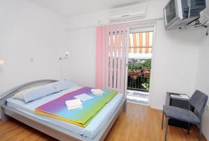 - une chambre avec un lit et une grande fenêtre dans l'établissement Apartments and rooms with parking space Senj - 5569, à Senj