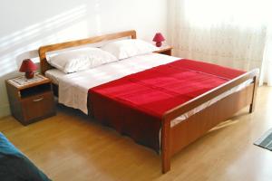 Un dormitorio con una cama con una manta roja. en Apartments by the sea Klenovica, Novi Vinodolski - 5581, en Klenovica