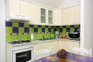a kitchen with white cabinets and a table with a pineapple at Apartments with a parking space Bol, Brac - 5642 in Bol +17 photos