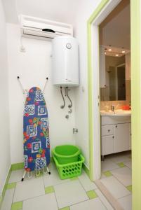 a bathroom with a water heater and a green basket at Apartments with a parking space Bol, Brac - 5642 in Bol