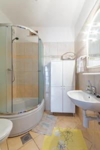 a bathroom with a tub and a sink and a shower at Apartments by the sea Pucisca, Brac - 5625 in Pučišća
