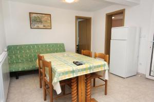 a kitchen with a table and chairs and a refrigerator at Apartments by the sea Splitska, Brac - 5664 in Splitska