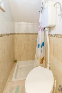 a bathroom with a toilet and a bath tub at Apartments by the sea Pucisca, Brac - 5625 in Pučišća