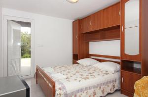 a bedroom with a bed with a wooden headboard at Apartments by the sea Splitska, Brac - 5664 in Splitska