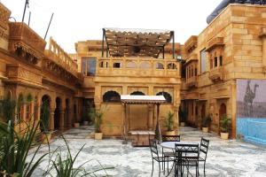 einen Innenhof eines Gebäudes mit Stühlen und einem Tisch in der Unterkunft Hotel Grand Khalifa in Jaisalmer