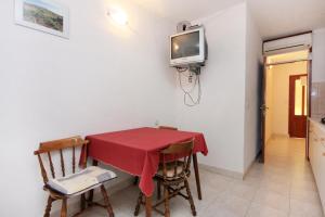 a dining room with a table and a tv on the wall at Apartments by the sea Cove Solotisa, Hvar - 5610 in Bogomolje