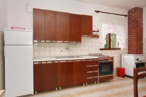 cocina con armarios de madera y nevera blanca en Apartments with WiFi Supetar, Brac - 5667, en Supetar