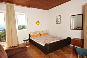 sypialnia z łóżkiem i kanapą w obiekcie Apartments by the sea Klenovica, Novi Vinodolski - 5557 w mieście Klenovica