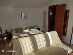a bedroom with a bed and a couch in it at Apartments by the sea Selce, Crikvenica - 5550 in Selce