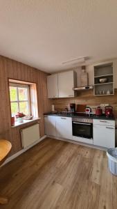 a kitchen with white appliances and a wooden floor at Naturhof Buschwiesen - Wohnung Nandu in Wilsum