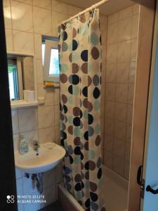 a bathroom with a shower curtain and a sink at Apartments by the sea Selce, Crikvenica - 5550 in Selce