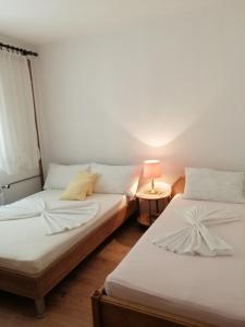two beds in a room with a lamp on a table at Apartments with a parking space Dramalj, Crikvenica - 5592 in Dramalj
