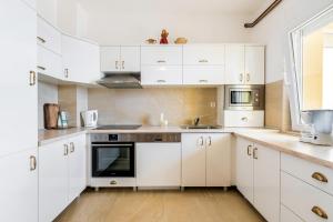 cocina blanca con armarios blancos y ventana en Apartments with a parking space Dramalj, Crikvenica - 5592, en Dramalj