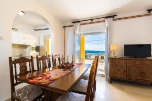 a kitchen and dining room with a table and a television at Apartments with parking space Dramalj, Crikvenica - 5592 in Dramalj