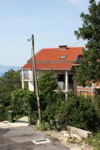uma casa com um telhado vermelho e uma rua em Apartments for families with children Crikvenica - 5554 em Crikvenica