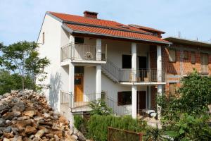 Uma casa com um monte de pedras à frente. em Apartments for families with children Crikvenica - 5554 em Crikvenica