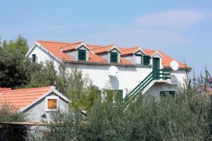 ein weißes Haus mit roten Dächern und Bäumen in der Unterkunft Apartments by the sea Mirca, Brac - 5655 in Mirce