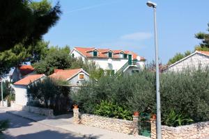 ein Haus mit einem Zaun und einer Straßenbeleuchtung in der Unterkunft Apartments by the sea Mirca, Brac - 5655 in Mirce