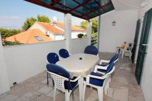 a table and chairs on a patio with a view of a house at Apartments by the sea Mirca, Brac - 5655 in Mirce