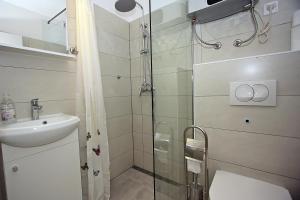 y baño con ducha, aseo y lavamanos. en Apartments with WiFi Supetar, Brac - 5665, en Supetar
