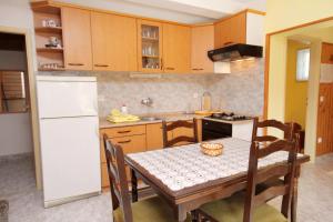 a kitchen with a table and a white refrigerator at Apartment Postira 5659a in Postira