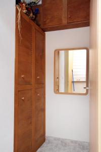 a bathroom with a mirror and a wooden door at Apartment Postira 5659a in Postira