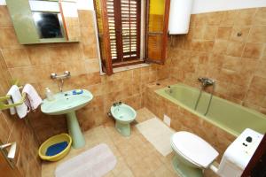 ein Badezimmer mit einem Waschbecken, einem WC und einer Badewanne in der Unterkunft Apartments by the sea Sumartin, Brac - 5615 in Sumartin