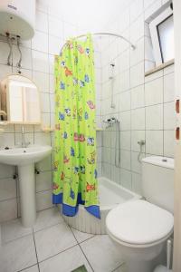 łazienka z zasłoną prysznicową, toaletą i umywalką w obiekcie Apartments with a parking space Bol, Brac - 5641 w Bol